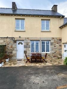 a house with a table and benches in front of it at Gites L etape conviviale in Guitté