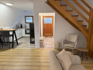 a living room with a couch and a table and a kitchen at Ferienhaus Reuthsee Natur & Komfort & hundefreundlicher Urlaub in der Rhön in Sulzdorf an der Lederhecke