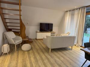 a living room with a couch and a tv at Ferienhaus Reuthsee Natur & Komfort & hundefreundlicher Urlaub in der Rhön in Sulzdorf an der Lederhecke