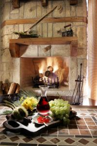 a fireplace with a bunch of grapes and a vase on a table at Abeliona Retreat in Ambeliona