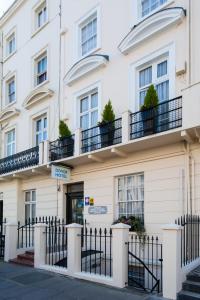 um edifício branco com uma cerca em frente em Dover Hotel - B&B em Londres