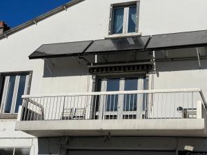 Onet le ChâteauにあるLes 4 saisonsの白い建物のバルコニー(椅子付)