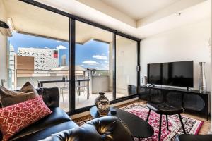 a living room with a couch and a large window at VAQUAY Alkina In Hawthorn in Melbourne