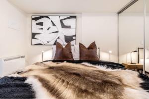 a bedroom with a bed with a fur blanket and pillows at VAQUAY Alkina In Hawthorn in Melbourne