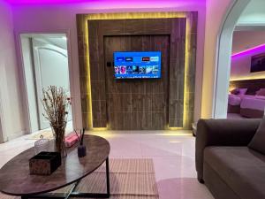 sala de estar con sofá y mesa frente a una puerta en شقق زهرة السلام الفاخرة, en Medina