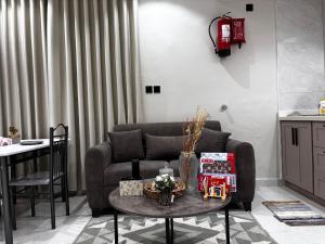 una sala de estar con un sofá y una mesa en شقق زهرة السلام الفاخرة, en Medina 7 fotos más