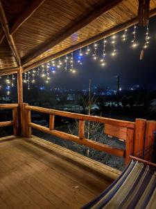 a porch with lights and a hammock on a deck at Cabana Mareea -Lunca Bradului in Lunca Bradului