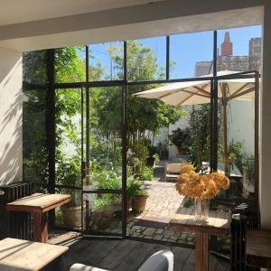 アル・アン・レにあるHôtel Le Sénéchalのパティオ(テーブル、椅子付)、大きな窓が備わります。