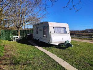 a white trailer parked in a grass field at Caravane avec spa privatif en campagne in Apremont