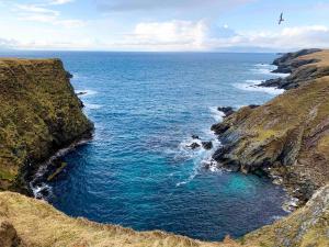 ラーウィックにあるStunning 1 Bedroom Lerwick Town Centre Apartmentの崖上の海の空