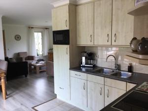 eine Küche mit Spüle und ein Wohnzimmer in der Unterkunft Oons hoes in Rossum