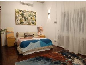 a bedroom with a bed and a painting on the wall at Soho Stay in Kuala Terengganu