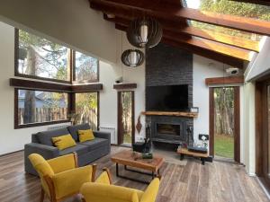a living room with a couch and a fireplace at CASA AZUL LIMAY VILLA LA ANGOSTURA in Villa La Angostura