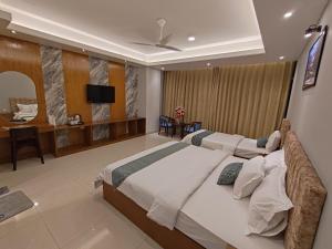 a bedroom with two beds and a flat screen tv at Sylhet Paradise Inn in Sylhet