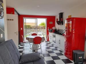 een keuken met een rode koelkast en een tafel bij maison Américan Beach in Longeville-sur-Mer