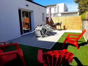 een terras met rode stoelen en een tafel op het gras bij maison Américan Beach in Longeville-sur-Mer +16 foto's