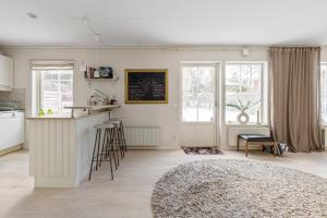 a kitchen and living room with a counter and some windows at Mysig villa Stockholm in Stockholm