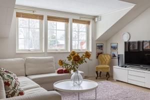 a living room with a couch and a tv at Mysig villa Stockholm in Stockholm