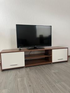 a flat screen tv sitting on top of a wooden entertainment center at Alexander s Ferienwohnungen in Olpe