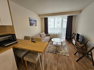 una sala de estar con un sofá y una mesa en Forest Chamkoria Apartment, en Borovets