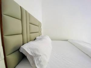 a white bed with a pillow in a room at Beautiful Green 7BHK Villa in Alibaug