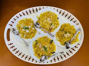a plate of food with spoons on a table at Beautiful Green 7BHK Villa in Alibaug