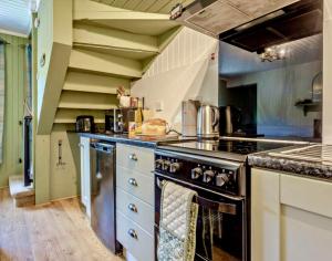 a kitchen with a stove and a counter top at Rosemount Bothy - Highland Cottage in Garve +72 photos