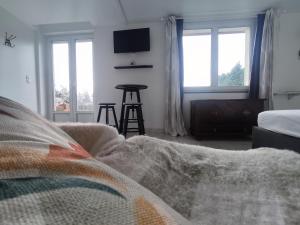 a bedroom with a bed and a table and windows at Le Magg in Feignies