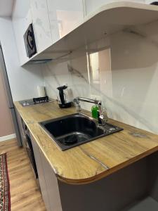 eine Küche mit einer Spüle und einer hölzernen Arbeitsplatte in der Unterkunft Apartments with Registan view in Samarkand