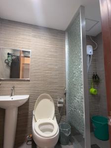 a bathroom with a toilet and a sink and a shower at Logan Apartments in Bantayan Island +49 photos