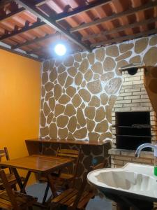 a room with a table and a stone wall at Aconchego do Áureo in Pacoti +2 photos