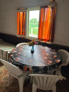 a dining room table with a vase of flowers on it at Áfricano in Barra de Valizas