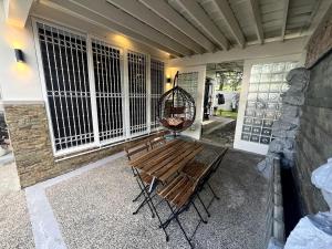 a porch with a bench and a swing at 4BR Tagaytay House Staycation near Sky Ranch in Tagaytay