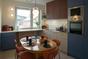a kitchen with a wooden table and chairs in a kitchen at Villa Turris Apartamenty przy Muszyńskim Zamku in Muszyna
