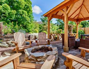 a patio with a fire pit and a wooden pavilion at Rosemount Cottage TWO - Highland Cottage in Garve