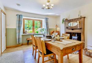 a dining room with a wooden table and chairs at Rosemount Cottage TWO - Highland Cottage in Garve