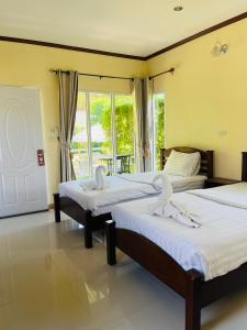 瑶亚岛Koh Yao Modern Inn -SHA Plus的有窗户的房间里有两张床