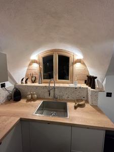 Una encimera de cocina con un fregadero y una ventana. en Appartement neuf à 300m des pistes, en Saint-Chaffrey