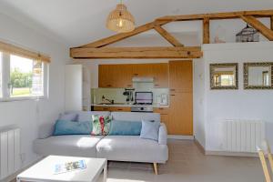 a living room with a couch and a kitchen at Gîte Bellevue - cosy huisje op vakantiepark in Jayac