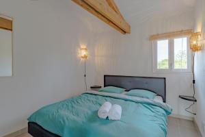 a bedroom with a bed with white shoes on it at Gîte Bellevue - cosy huisje op vakantiepark in Jayac