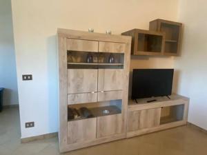 a wooden entertainment center with a television in a room at Splendida casa a Roma vicino al mare in Ostia Antica