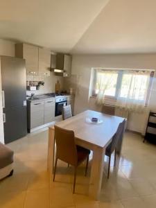 a kitchen with a table and chairs and a kitchen with a refrigerator at Splendida casa a Roma vicino al mare in Ostia Antica