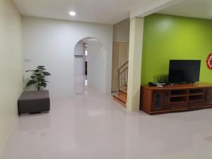 a living room with a tv and a green wall at Kuching Homestay Double Storey in Kuching