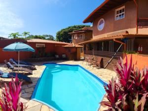 a swimming pool in front of a house at Solar del Mar in Praia do Rosa