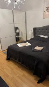 a bedroom with a black bed with two towels on it at Downtown Chalet in Braunschweig in Braunschweig