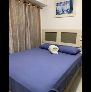 a bedroom with a blue bed with a hat on it at Apartamento pé na areia na praia de enseadas dos corais-Gaibu, em frente as piscinas naturais in Cabo de Santo Agostinho