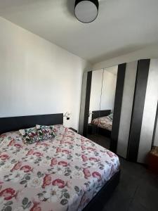 a bedroom with a bed with a floral bedspread at Casa dolce casa - Metro in Sesto San Giovanni