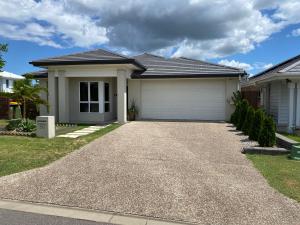 a house with a driveway in front of it at Modern Four Bedroom Holiday Home Available in Deebing Heights in Loamside