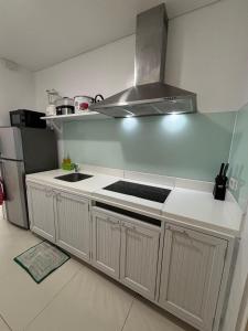 纳苏格布Beach condos at Pico de Loro Cove - Wi-Fi & Netflix, 42-50''TVs with Cignal cable, Uratex beds & pillows, equipped kitchen, balcony, parking - guest registration fee is not included的带水槽和炉灶的厨房 顶部烤箱