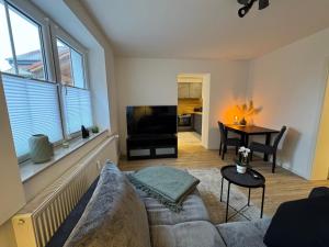 a living room with a couch and a tv and a table at Gutshof von Gemünden Ferienwohnung 2 in Bernau bei Berlin